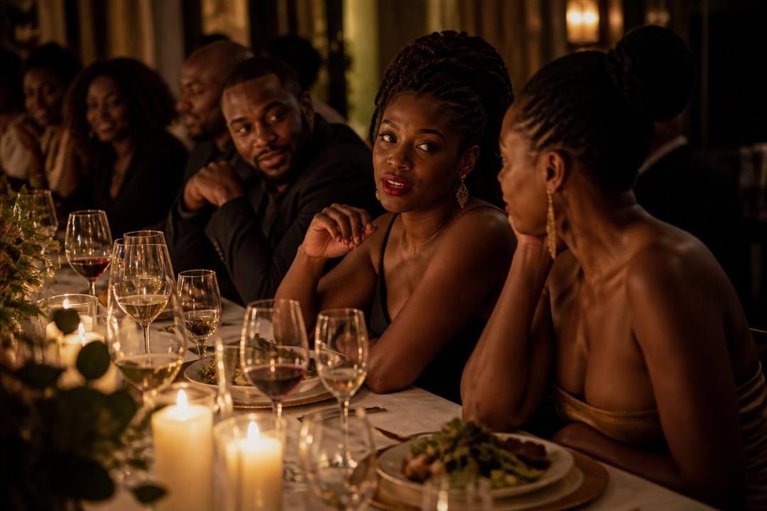 A candlelit private dinner party with guests in evening attire
